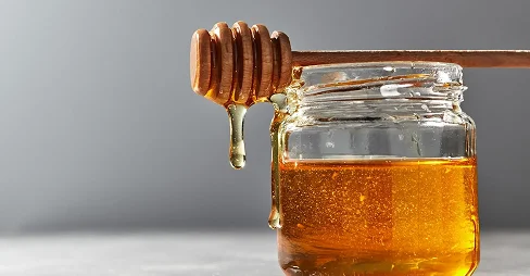 dripping honey in the glass jar