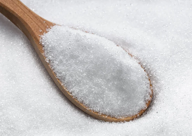 sugar on the table with wooden spoon